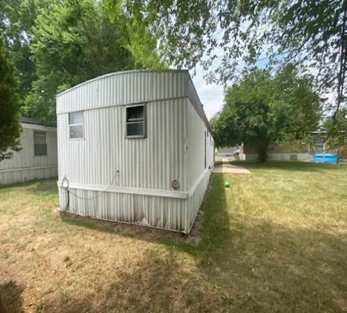 A mobile home is parked in a yard.