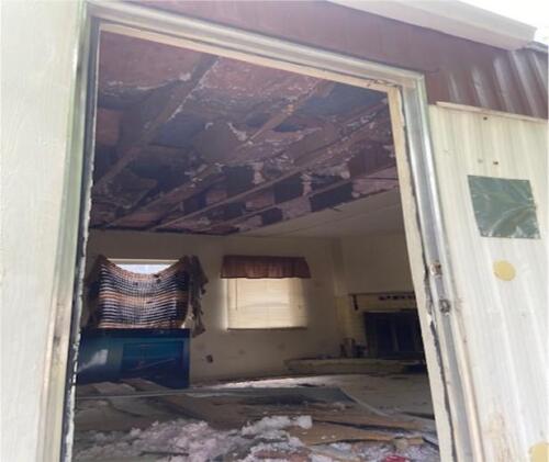 The inside of a house with a roof that has been ripped off.