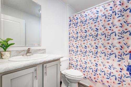 A bathroom with a blue and white floral shower curtain.