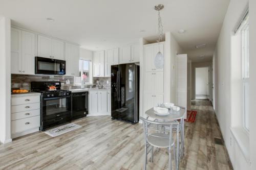 A kitchen with white cabinets and hardwood floors.