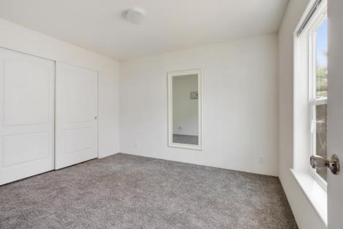 An empty room with gray carpet and white walls.