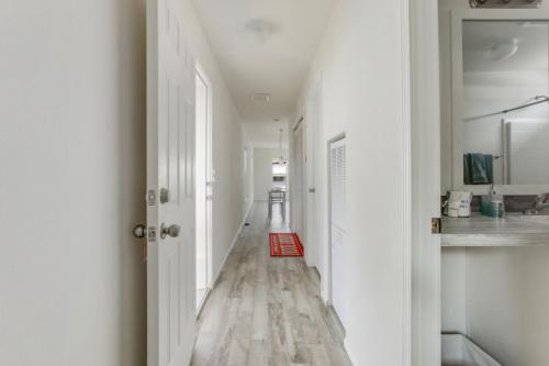 A hallway with white walls and hardwood floors.